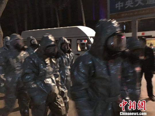 十几名身着防护服的人员头戴面具进入事发地。　胡健 摄